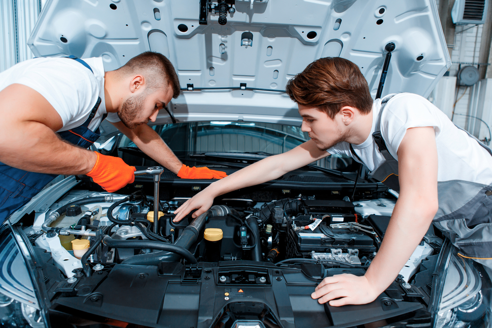 Two people working on a car engine

Description automatically generated with low confidence