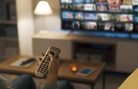 Sportsurge Not Working? Top Sites to Watch Live Sports Right Now Young woman relaxing on the couch at home and watching videos